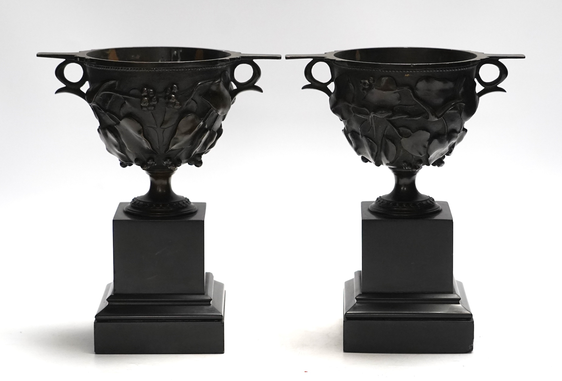 After the Antique, a pair of late 19th century bronze skyphos vessels on polished slate bases, 22cm